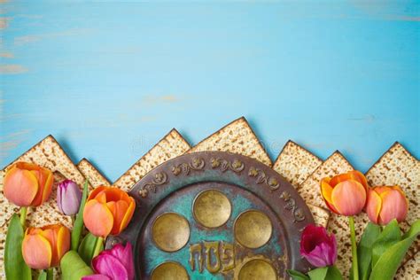 jewish holiday passover celebration concept with seder plate matzah and tulip flowers on wooden