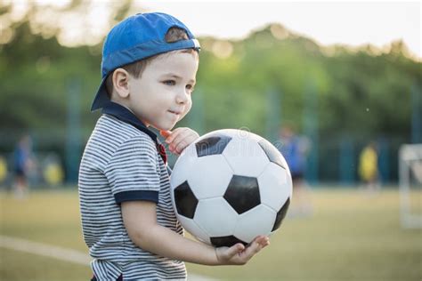 Little Boy Play Soccer At Outdoorboy Running Towards Ball On A Field