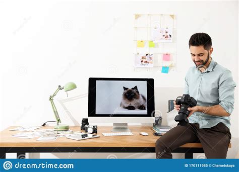 Professional Photographer With Camera Working In Modern Office Stock