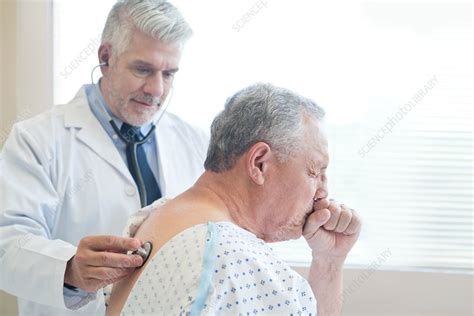 Male Doctor Examining Patient In Hospital Gown Stock Image F020