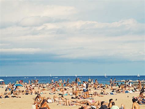 Beach Is Crowded With People On Tourism Enjoying The Summer Holiday And Vacation In Barcelona