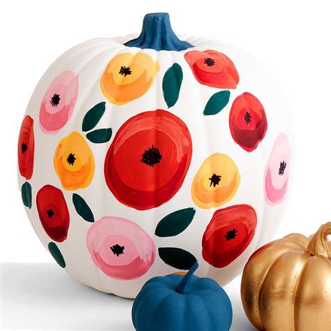 Two Painted Pumpkins Sitting Next To Each Other On A White Surface With