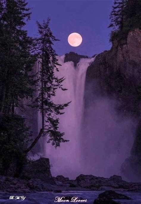 The Full Moon Is Setting Over A Waterfall