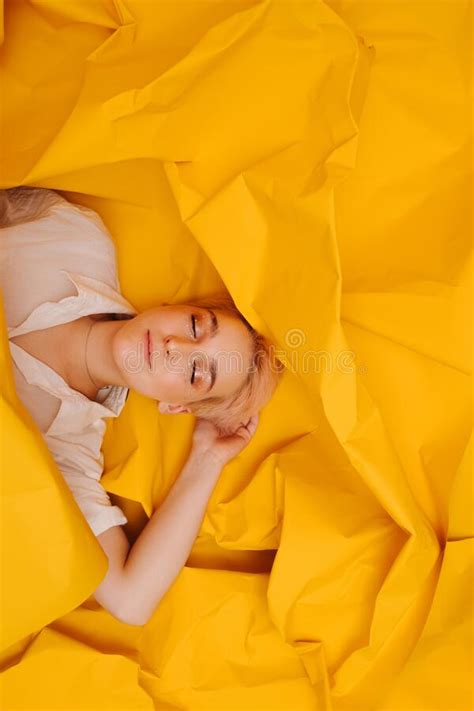 Happy Young Woman With Short Hair Lying On Her Back On Yellow Cramped