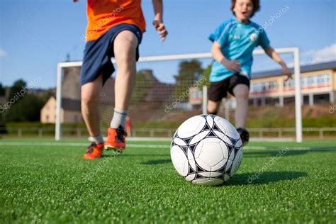 Busca millones de imágenes de niños jugando futbol de alta calidad a precios muy económicos en el banco de imágenes 123rf. Dos niños jugando al fútbol en el campo de fútbol — Foto de stock © racorn #27100467