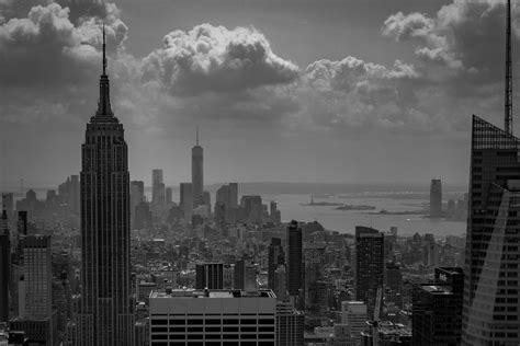 Grayscale Photograph Of City Buildings Under Cloudy Sky Hd Wallpaper