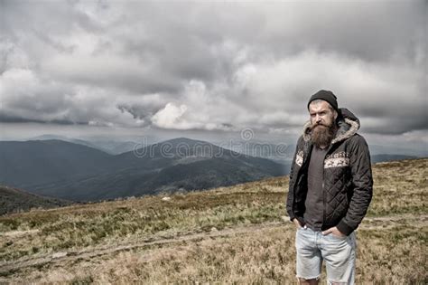 Hipster Bearded Man On Mountain Top On Natural Cloudy Sky Stock Photo
