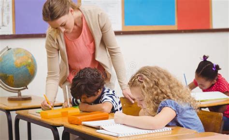 Pretty Teacher Helping Pupil In Classroom Stock Image Image Of