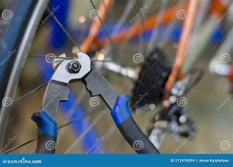 Bicycle Mechanic In A Workshop In The Repair Process Holds A Tool In