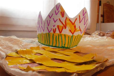 A paper crown sitting on top of a table next to some yellow pieces of paper