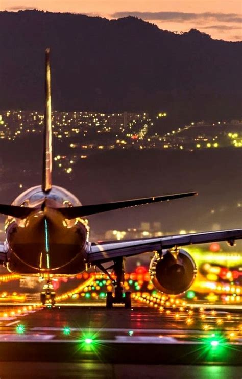 an airplane is taking off from the runway at night with colorful lights on it s wings