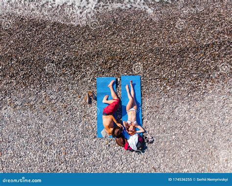 Aerial Top Down View A Couple Of Man And Woman Lie On A Blue Rug For