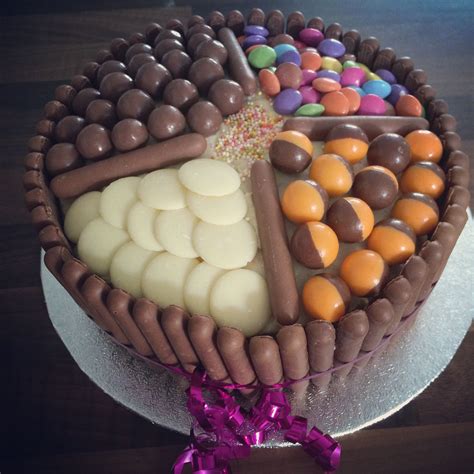 There Is A Cake Decorated With Chocolates And Candies