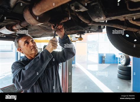 Car Mechanic Working Under A Automobile In Garage Auto Mechanic