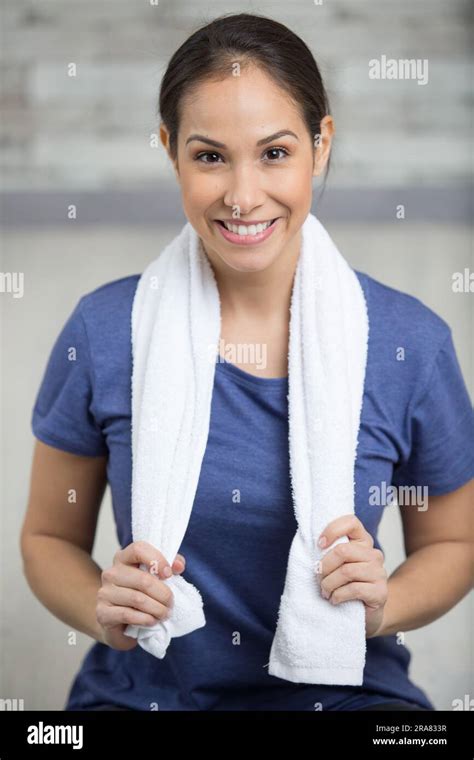 Woman Having Rest After Workout With Towel Around Her Neck Stock Photo