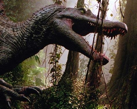 Two Large Dinosaurs Are In The Woods With Trees And Bushes Behind Them