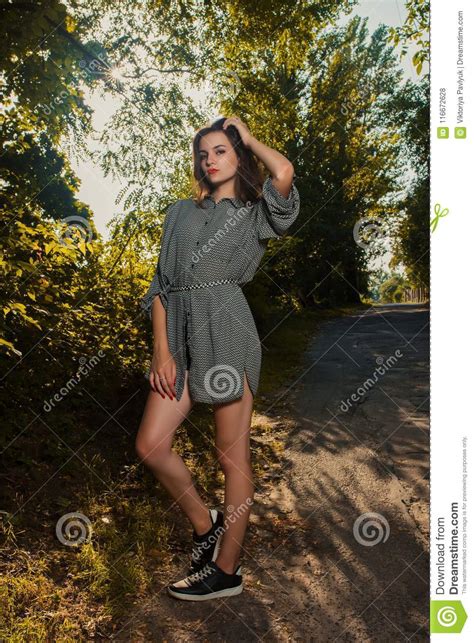 Glamor Brunette Woman In Trendy Apparel Posing On A Green Tree B Stock