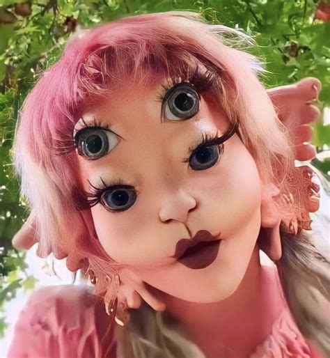 A Close Up Of A Doll With Pink Hair And Big Eyes