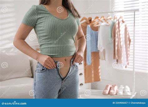 woman trying to put on tight jeans at home closeup space for text stock image image of