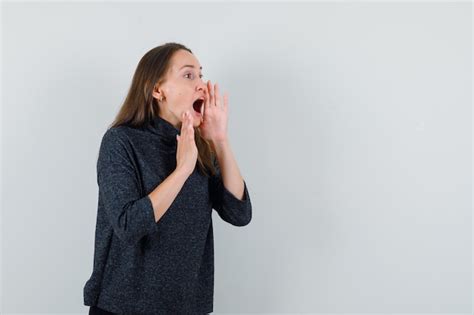 Free Photo Young Woman Shouting With Hand Near Mouth In Shirt And