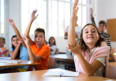 Diligent Tween Schoolgirl Raising Hand During Lesson In Classroom Stock