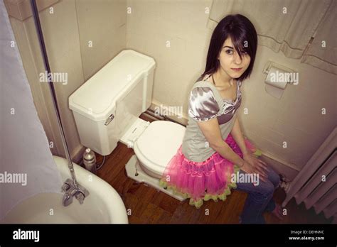 Junge Frau Sitzt Auf Dem Rand Ihrer Toilette Modell Und Der Eigenschaft Freigegeben