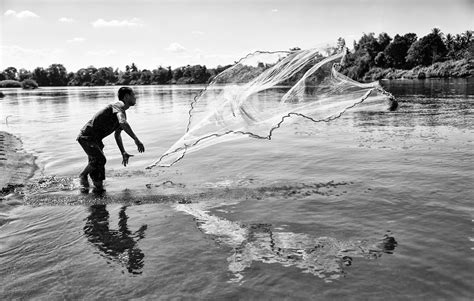 Grayscale Photo Of Man Throwing A Fishing Net · Free Stock Photo
