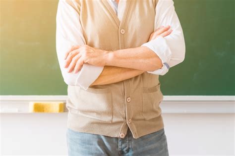 Free Photo Professor With Arms Crossed Standing Against Chalkboard