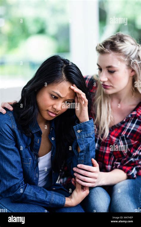 Young Woman Consoling Depressed Female Friend At Home Stock Photo Alamy