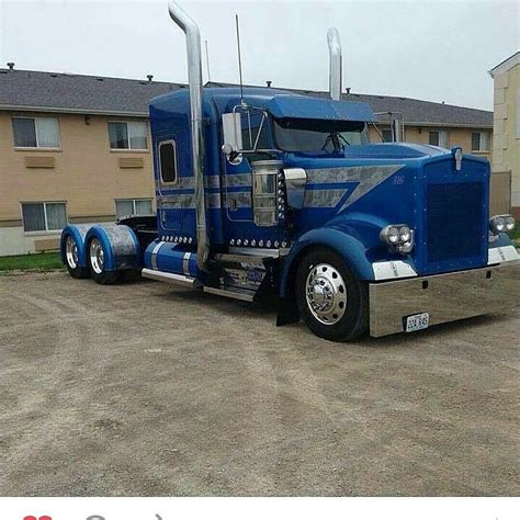 A Blue Semi Truck Parked In Front Of A Building