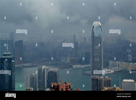 High Modern Buildings In Fog And Thick Rain Clouds Of Hong Kong Harbor