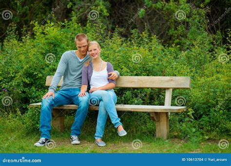 Young Couple Seated On A Bench In The Garden Stock Photo Image Of