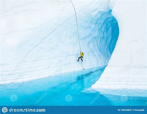 Man Absailing Into Flooded Ice Cave On The Matanuska