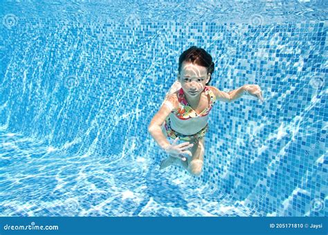 Little Child Swims Underwater In Swimming Pool Happy Active Baby Girl
