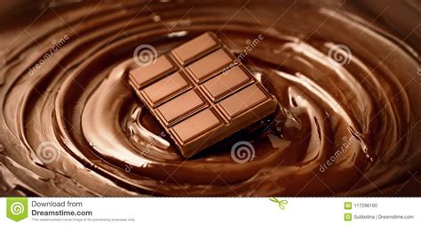 barra di cioccolato sopra il fondo fuso del liquido di turbinio del cioccolato fondente contesto