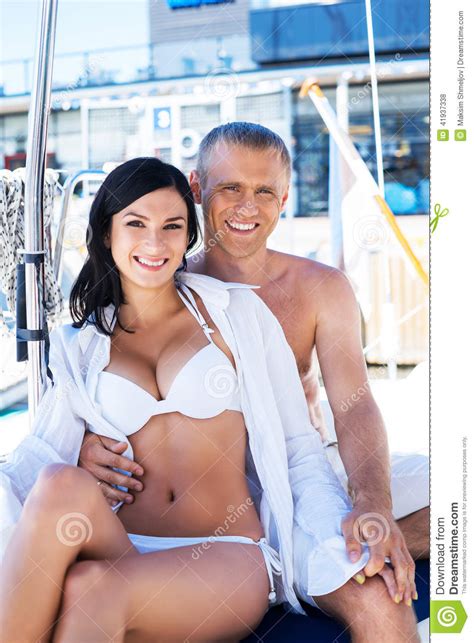 Rich Man And A Beautiful Woman In Swimsuits On A Boat Stock Photo
