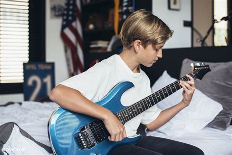 Young Boy Playing Electrical Guitar In His Bedroom Premium Image By