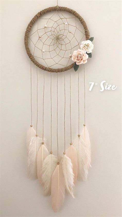 A Dream Catcher With Flowers And Feathers Hanging On The Wall