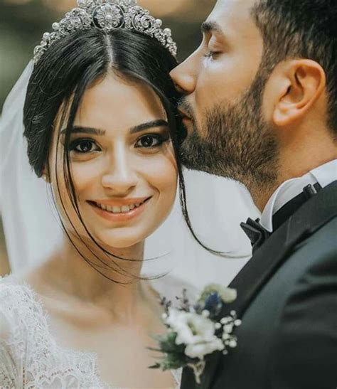 A Bride And Groom Are Kissing Each Other In Front Of The Camera While