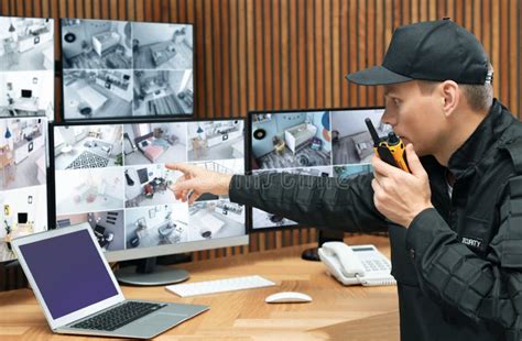 Security Guard With Portable Transmitter Monitoring Modern Cctv Cameras