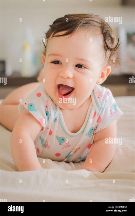 Portrait Of A Smiling Baby Girl Lying On Her Front Stock Photo Alamy
