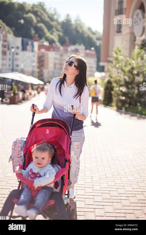 Young Mother Walking With Baby In Stroller Stock Photo Alamy