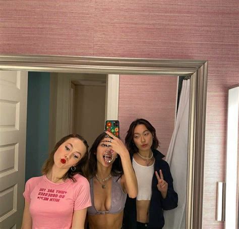 Three Women Taking A Selfie In Front Of A Mirror With Their Mouths Wide