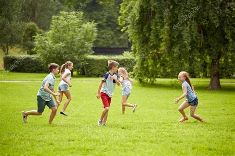 Niños Felices Corriendo Y Jugando Al Aire Libre Fotografía De Stock