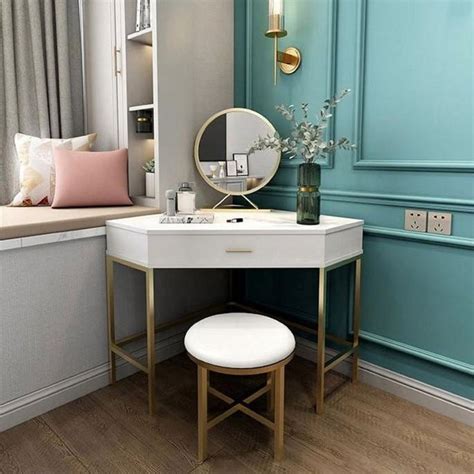 A Dressing Table With A Mirror And Stool In Front Of A Blue Painted