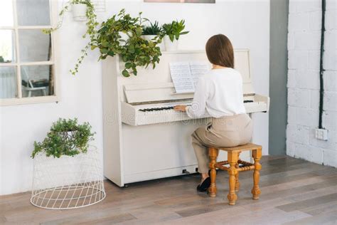 Back View Of Unrecognizable Young Woman Pianist Playing On White