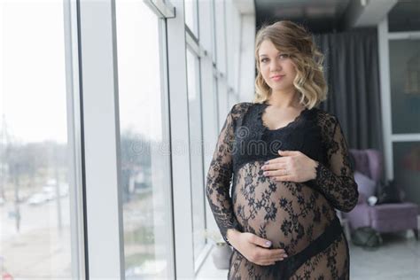 pregnant woman in a beautiful lace dress holds belly stock image image of indoors birth