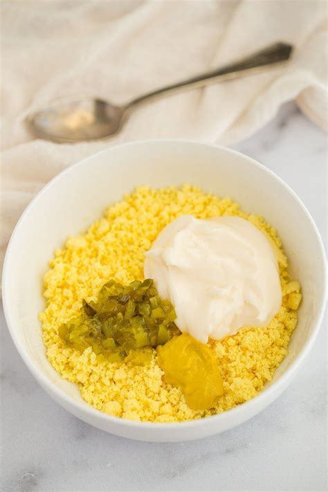 A White Bowl Filled With Crumbled Egg Yolks Mayonnaise Mustard And