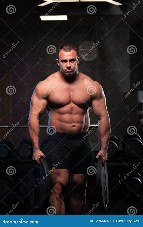 männlicher bodybuilder mit dem nackten torso der in der turnhalle aufwirft stockbild bild von