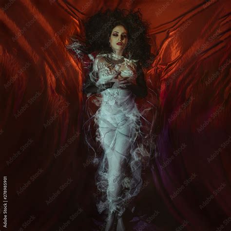 Vampire Halloween Woman Portrait Beauty Sexy Vampire Girl Lying In Red Satin Fabric Vampire